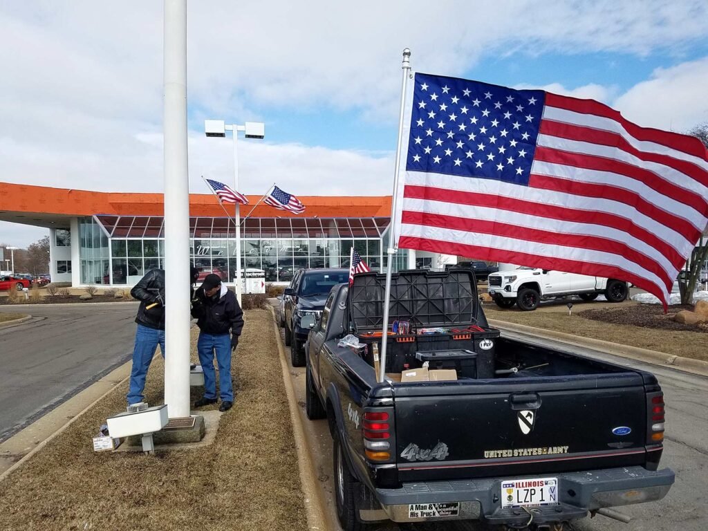 Installing new flag at Lou Bachrodt Chevrolet